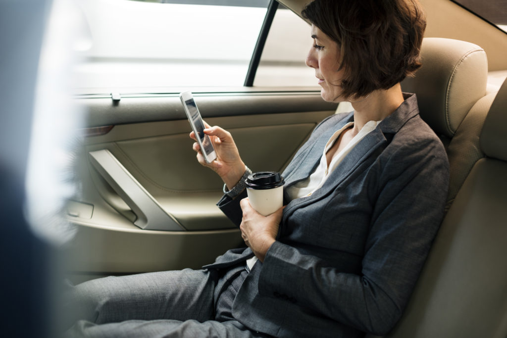 Businesswoman Using Smart Phone Car Inside